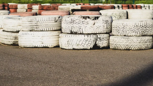 Barriera di sicurezza pista. pista da corsa asfaltata con pneumatici rossi e bianchi. gomme colorate stack. pista di karting — Foto Stock