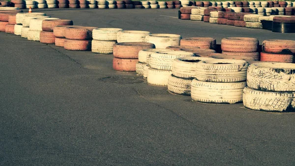 Race track safety barrier. asphalt racing track with red and white tires. colorful tires stack. karting racetrack