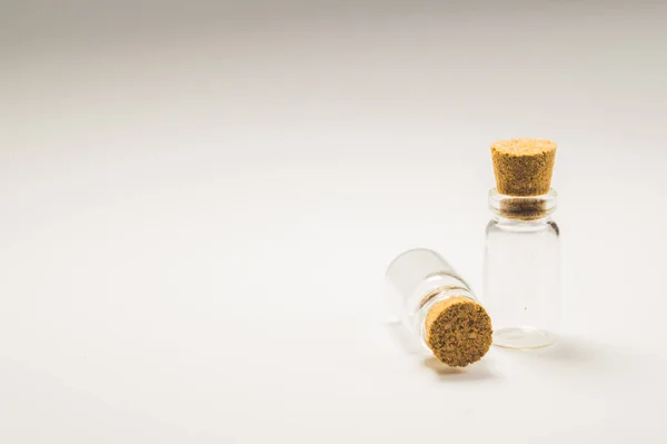 Αδειάστε μικρά μπουκάλια με πώμα από φελλό απομονωμένο σε λευκό. διαφανείς περιέκτες. δοκιμαστικούς σωλήνες. Χώρος αντιγραφής — Φωτογραφία Αρχείου