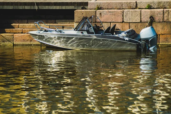 İskelede motorlu tekne. rıhtımda su taşımacılığı. gümüş tekne. su yansıması