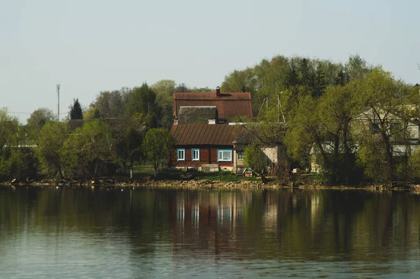 Lake house. house on the shore in the village. landscape with reflection on the water — Stock Photo, Image