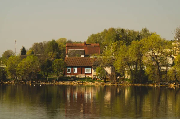 Lake house. house on the shore in the village. landscape with reflection on the water