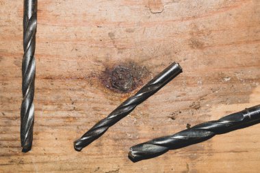 Ahşap bir masaüzerinde matkaplar. ahşap bir arka plan üzerinde matkap uçları yığını