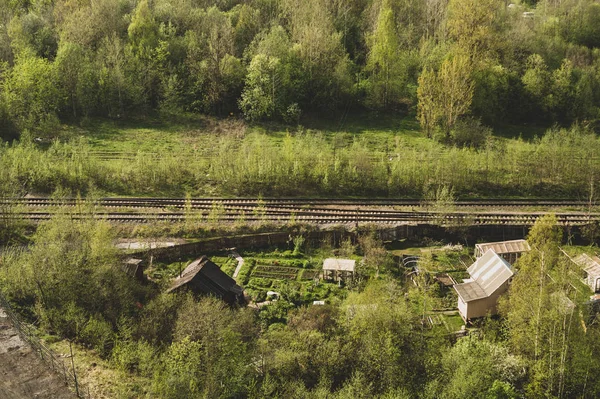 Huis met de tuin in de buurt van spoorlijnen. houten huis in het bos antenne. landelijk landschap — Stockfoto