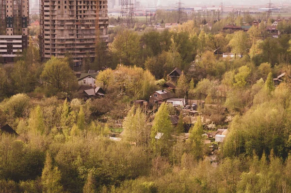 Casas de madera en el bosque cerca de la construcción de edificios modernos vista aérea. paisaje rural — Foto de Stock