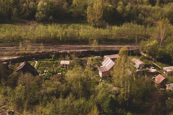 Dom z ogrodem w pobliżu linii kolejowych. drewnianym domu w antenę leśną. krajobrazu wiejskiego — Zdjęcie stockowe