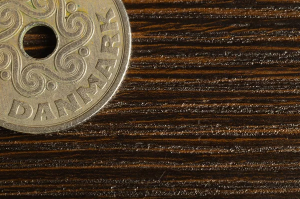 Danish coin on a wooden background. krone from Denmark close up. coin with hole — Stock Photo, Image