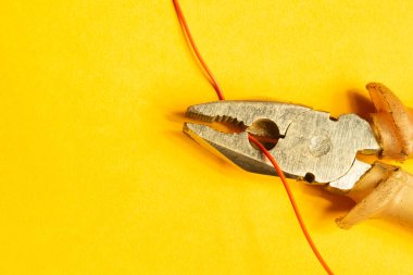 Pliers sarı arka plan üzerinde kırmızı bir tel keser. çalışma aracı