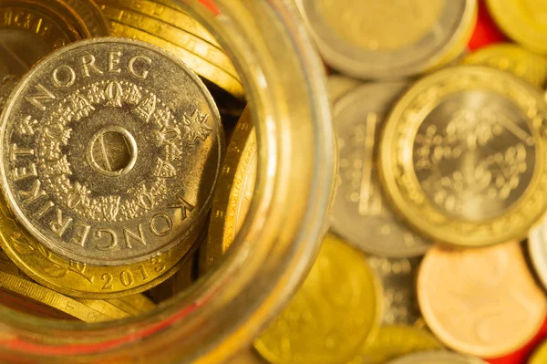 Coins of the various countries in a glass jar. metal coins of different denominations. finance background