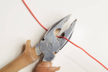 Pliers beyaz arka plan üzerinde kırmızı bir tel keser. çalışma aracı
