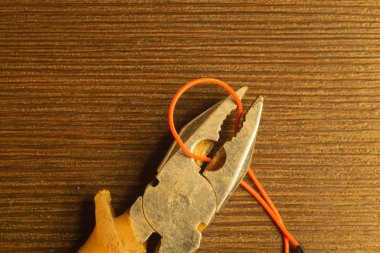 Pliers ahşap arka plan üzerinde kırmızı bir tel keser. turuncu saplı pliers. kopyalama alanı