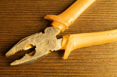 Ahşap arka plan üzerinde turuncu kolları ile Pliers. çalışma aracı