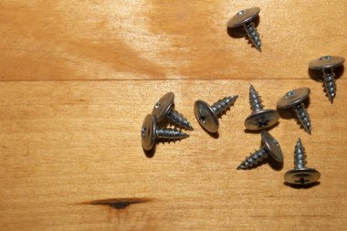 Ahşap arka plandaki vidalar.çalışma aletleri