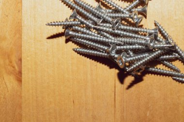 Ahşap arka plandaki vidalar.çalışma aletleri