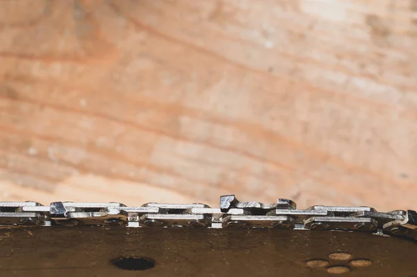 Chainsaw bar and cutting chain close up. blade of a chainsaw on a wooden background