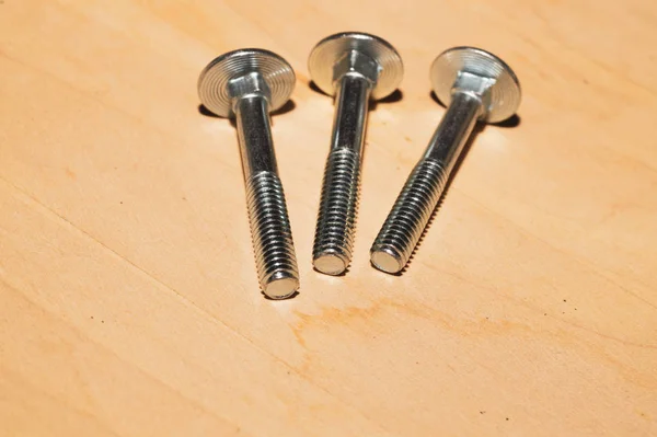 Screws on a wooden background.working tools — Stock Photo, Image