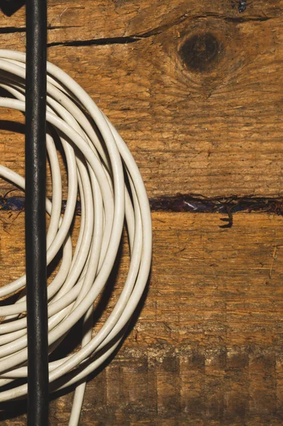 Witte en zwarte kabel op een houten achtergrond. verbindingsdraad — Stockfoto
