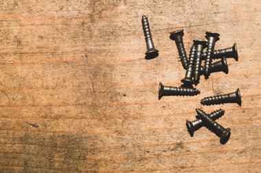 Ahşap arka plandaki vidalar.çalışma aletleri