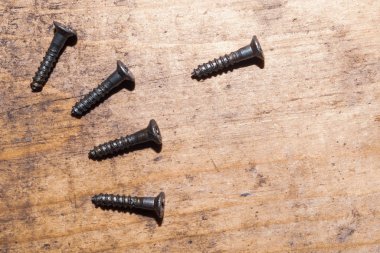 Ahşap arka plandaki vidalar.çalışma aletleri