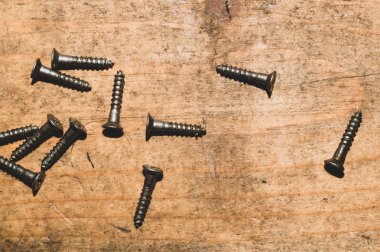 Ahşap arka plandaki vidalar.çalışma aletleri