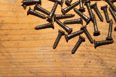 Ahşap arka plandaki vidalar.çalışma aletleri