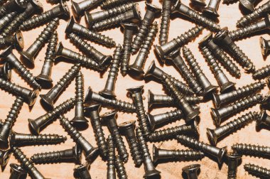 Ahşap arka plandaki vidalar.çalışma aletleri