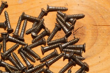 Ahşap arka plandaki vidalar.çalışma aletleri