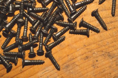 Ahşap arka plandaki vidalar.çalışma aletleri