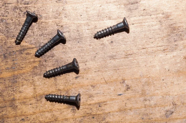 Ahşap arka plandaki vidalar.çalışma aletleri
