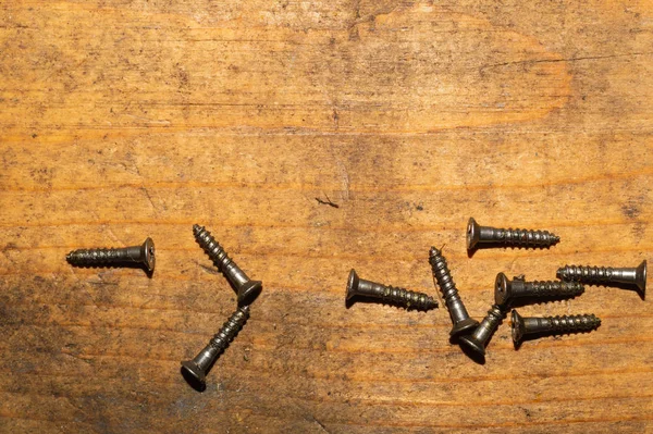 Ahşap arka plandaki vidalar.çalışma aletleri