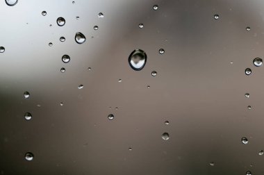 Pencere camındaki yağmur damlaları yakın. su damlaları soyut makro arka plan