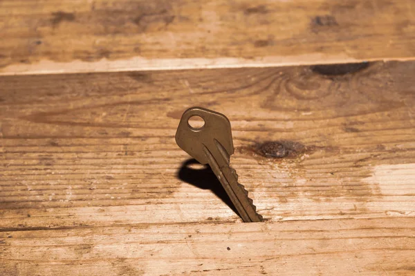 Chave presa na mesa. chave em um fundo de madeira. conceito de segurança e segurança — Fotografia de Stock