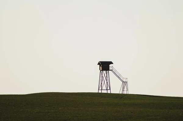 Lonely klocktorn. observation post står ensam på kullen. jaktstuga i fält. ensamhet Concept — Stockfoto