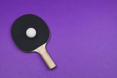 Siyah pinpon raketi ve arka planda izole edilmiş bir top. Masa tenisi için spor malzemeleri