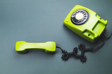 Cep telefonlu klasik bir telefon. Telefon ahizesi olan klasik yeşil bir telefon. Ofis geçmişi. Eski iletişim teknolojisi. Boşluğu kopyala
