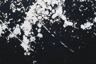 Beyaz lekeli siyah çelik plaka. Üzerinde boya lekeleri olan metal bir yüzey. Grunge dokusu. demir arkaplan