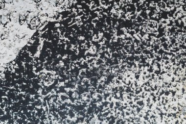 Beyaz lekeli siyah çelik plaka. Üzerinde boya lekeleri olan metal bir yüzey. Grunge dokusu. demir arkaplan