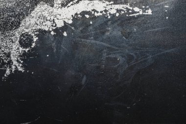 Beyaz lekeli siyah çelik plaka. Üzerinde boya lekeleri olan metal bir yüzey. Grunge dokusu. demir arkaplan