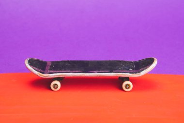 Renkli arka planda küçük bir kaykay. Parmaklar için küçük bir paten. Klavye kapanıyor. Boşluğu kopyala