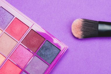 Mor arka planda pudralı makyaj fırçaları. çeşitli kozmetik fırçalar. cilt bakım aksesuarları