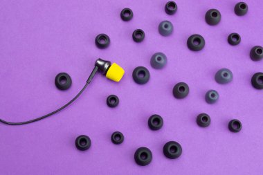 Bireysellik kavramı. Gri kapakçıkların arasında sarı kulak minderi olan kulaklık. Kulaklıklar. Modern tarz. ses ekipmanları