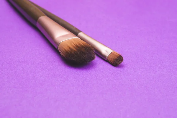 Makeup brushes on purple background. various cosmetic brushes close up. skin care accessories