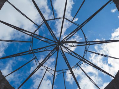 Harap olmuş bir çatı inşaatından gökyüzünün görüntüsü. Çelik gövde çatı montajı için