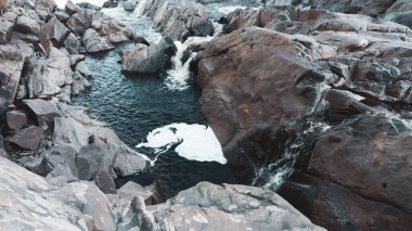 Nehir kayaların arasından akar. Taşların arasından akan su