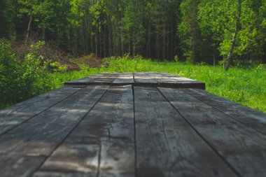 Parktaki ahşap masa. Yaz günü. Arkaplanda yeşil yapraklar