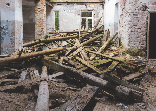 Ruined interior of old abandoned building. wooden logs of broken roof. destroyed house