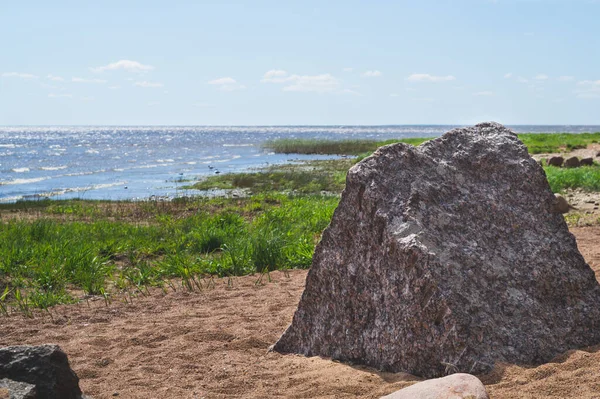 Big stone in the triangular prism shape on the sea shore. boulder on the coast. nature landscape