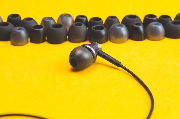 Auriculares Entre Los Cojines Los Oídos Sobre Fondo Amarillo Auriculares —  Fotos de Stock