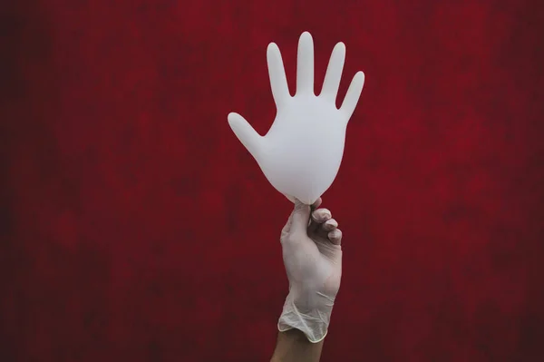 Hand Holds Inflated Protective Glove Red Background — Stock Photo, Image