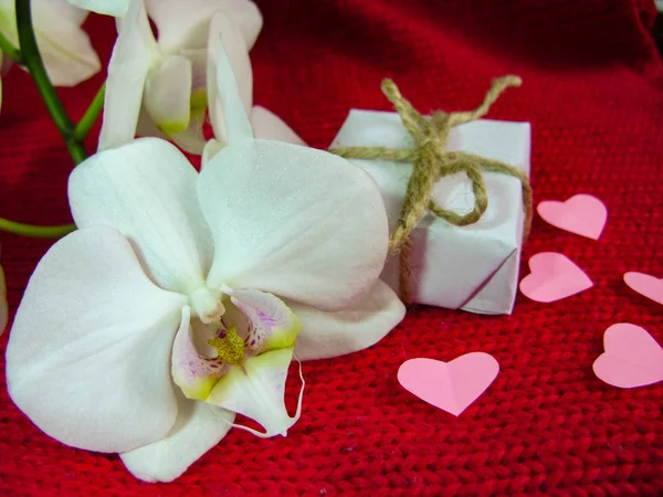 Orchidea e cuori su stoffa rossa, sfondo di San Valentino, giorno del matrimonio . — Foto Stock